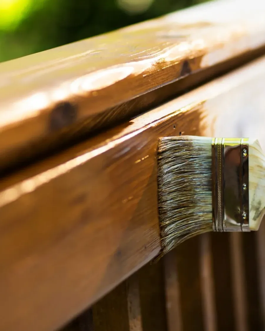 A brush laying stain along a wooden railing, close up — painting and finish work in New Bedford, MA