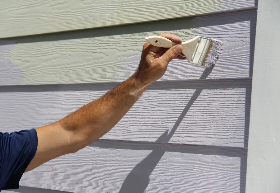 A brush painting a house's lap siding — exterior painting in New Bedford, MA