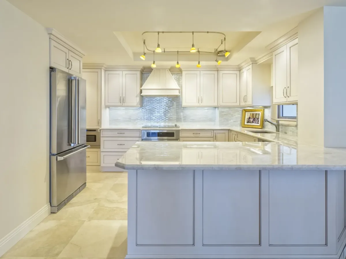 A large white kitchen with painted cabinets and a tiled floor — interior painting in New Bedford, MA