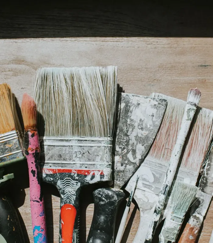 Well-used paint brushes laid side by side — house painting in New Bedford, MA