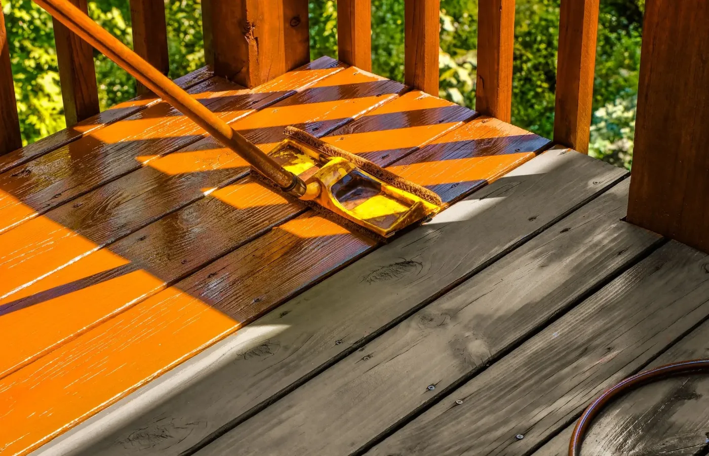 Stain going on with a pad over weathered wooden boards — exterior painting in New Bedford, MA